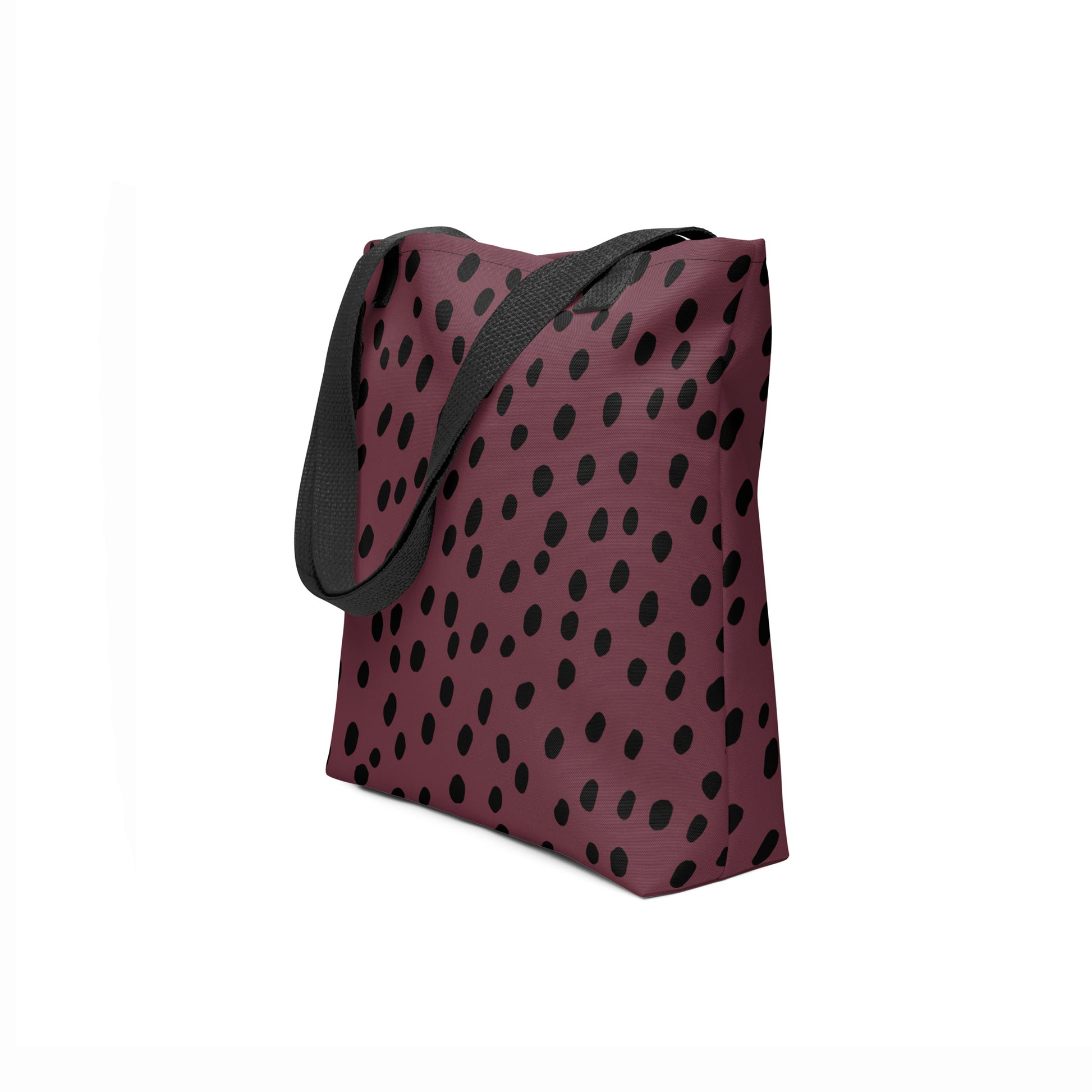 Side angle of TASHAU tote showing burgundy canvas with black dot design on a white background.