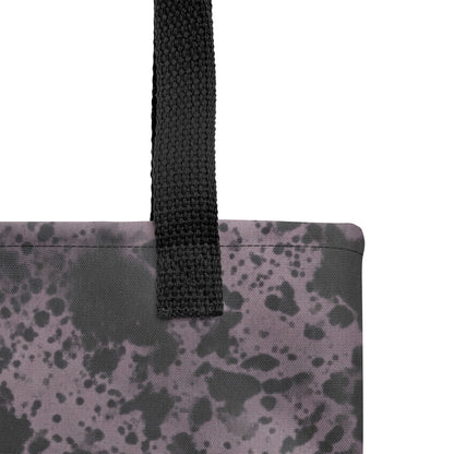 Close-up of a fashion tote bag with charcoal black and dusty purple artistic abstract print.