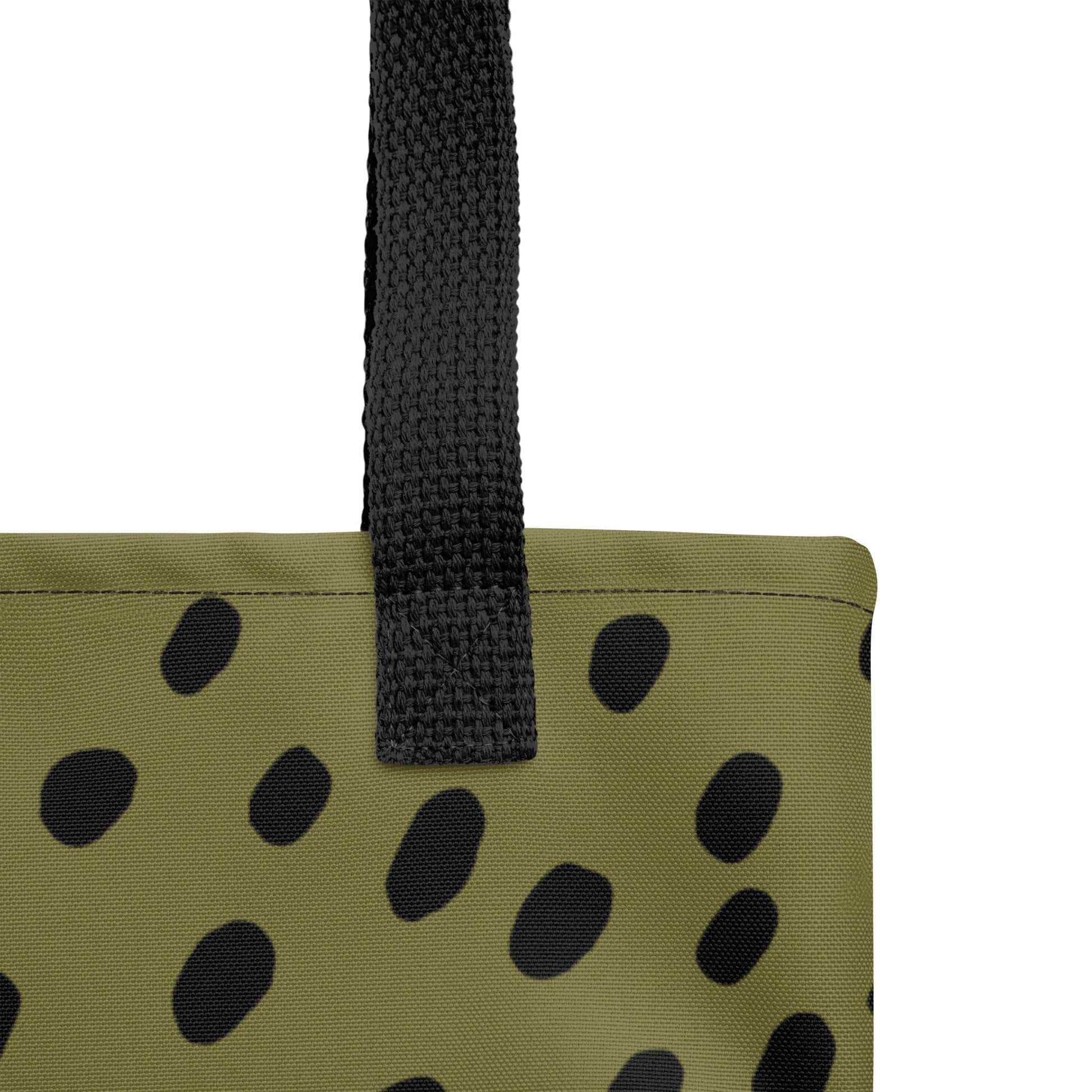 Close-up of TASHAU tote fabric showing olive canvas and black spots.