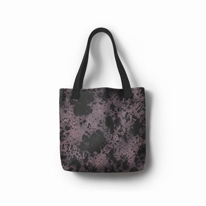 Front view of artistic tote bag in charcoal black and dusty purple abstract stone texture. Designed by TASHAU.