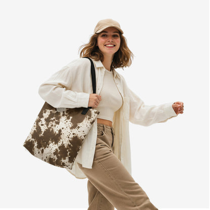 Woman carrying the Earthstone Whisper tote bag in beige and rustic brown abstract design, art by TASHAU.